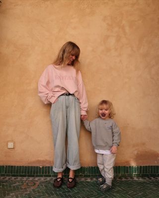 @_jeanettemadsen_ wearing blue jeans, a pink sweatshirt and mesh flats