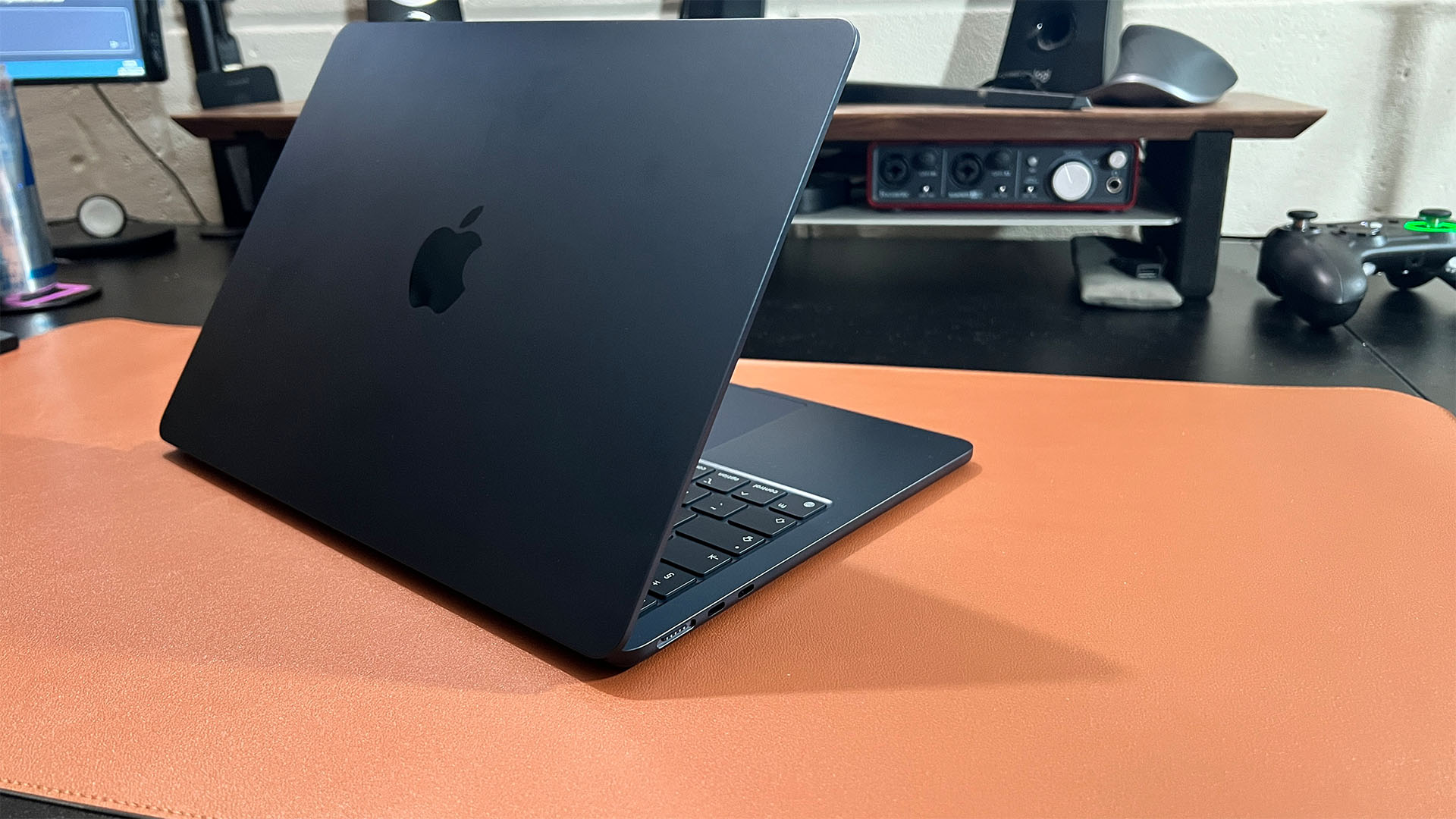 MacBook Air M2_l laptop من الخلف مفتوح قليلاً على المكتب