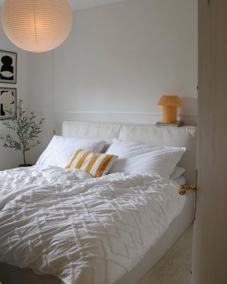 Bedroom with white bed and lamp