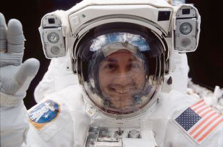 Mike Massimino, as seen in 2002 on a spacewalk outside of space shuttle Columbia to service the Hubble Space Telescope.