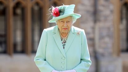 Queen Elizabeth II poses after awarding Captain Sir Thomas Moore with the insignia of Knight Bachelor at Windsor Castle on July 17, 2020 in Windsor, England. British World War II veteran Captain Tom Moore raised over £32 million for the NHS during the coronavirus pandemic