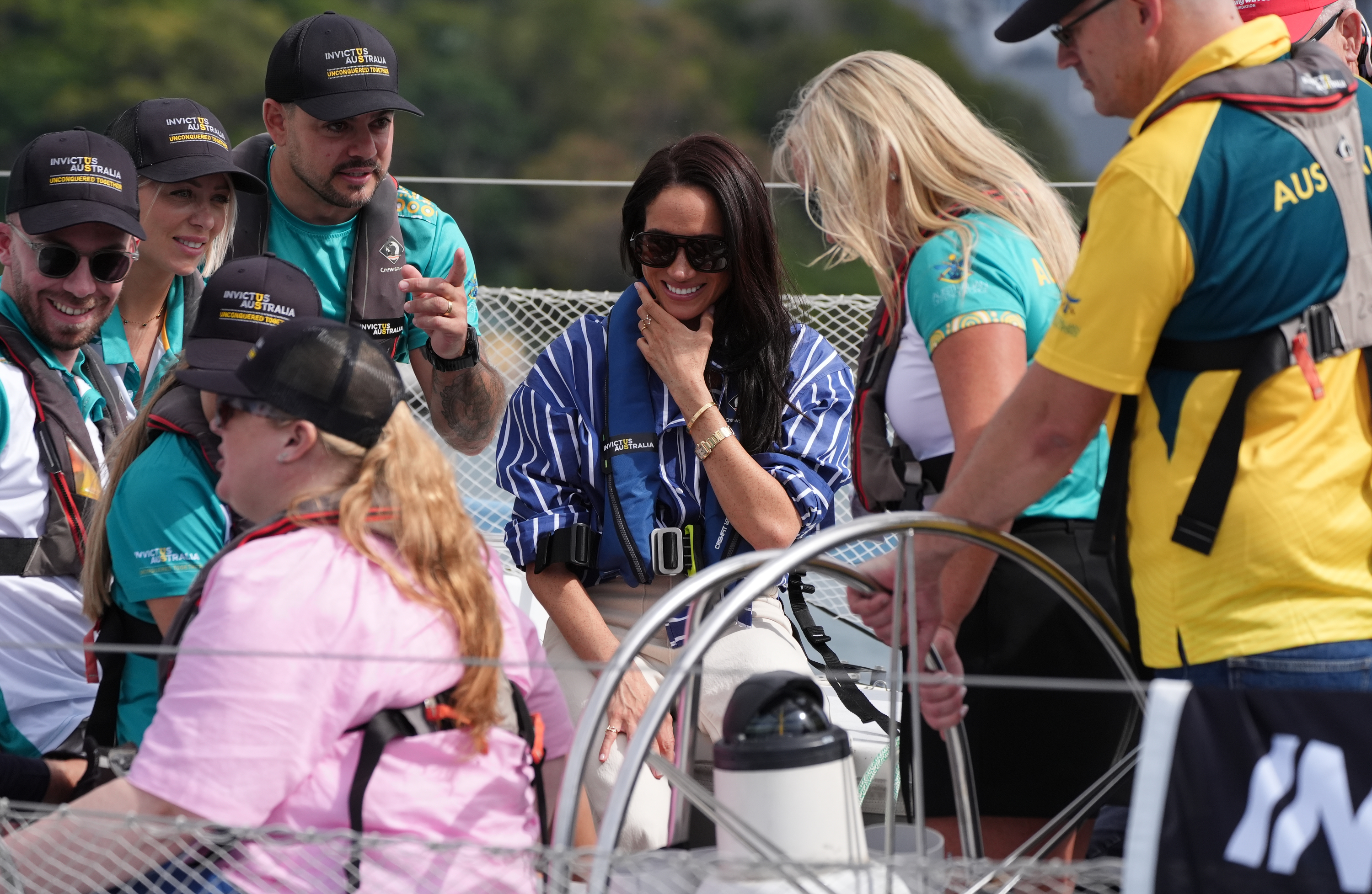 Meghan Markle wearing a blue striped shirt on a boat