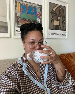 A woman taking a selfie drinking a cup of coffee