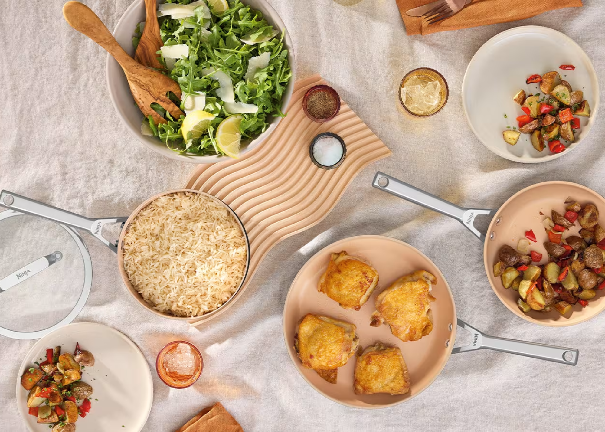 A dining table with Ninja cooking pans full of food