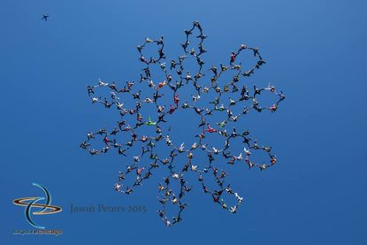 A group of 164 skydivers making a formation in the sky