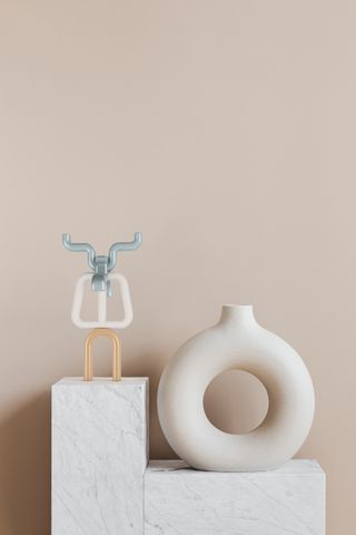 Therapeutic tool standing on slab of marble next to a white ornament