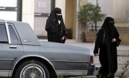 Two Saudi women walk past a parked car: A female Saudi activist, Manal al-Sharif, defied the conservative Muslim kingdom's ban on women driving and spent five days in jail as a result.