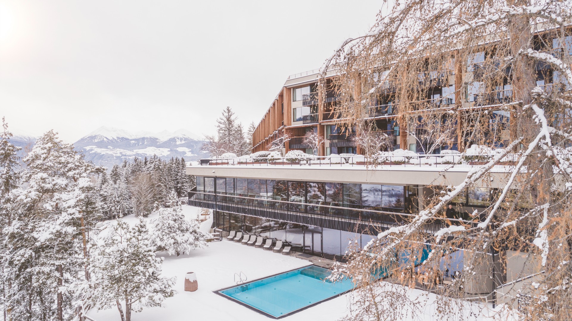 Exterior shot of the back of the My Arbor treetop hotel in the Dolomite mountains in winter snow