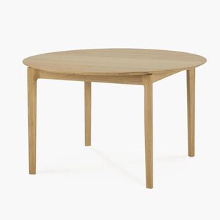 A light wood round dining table n a white background
