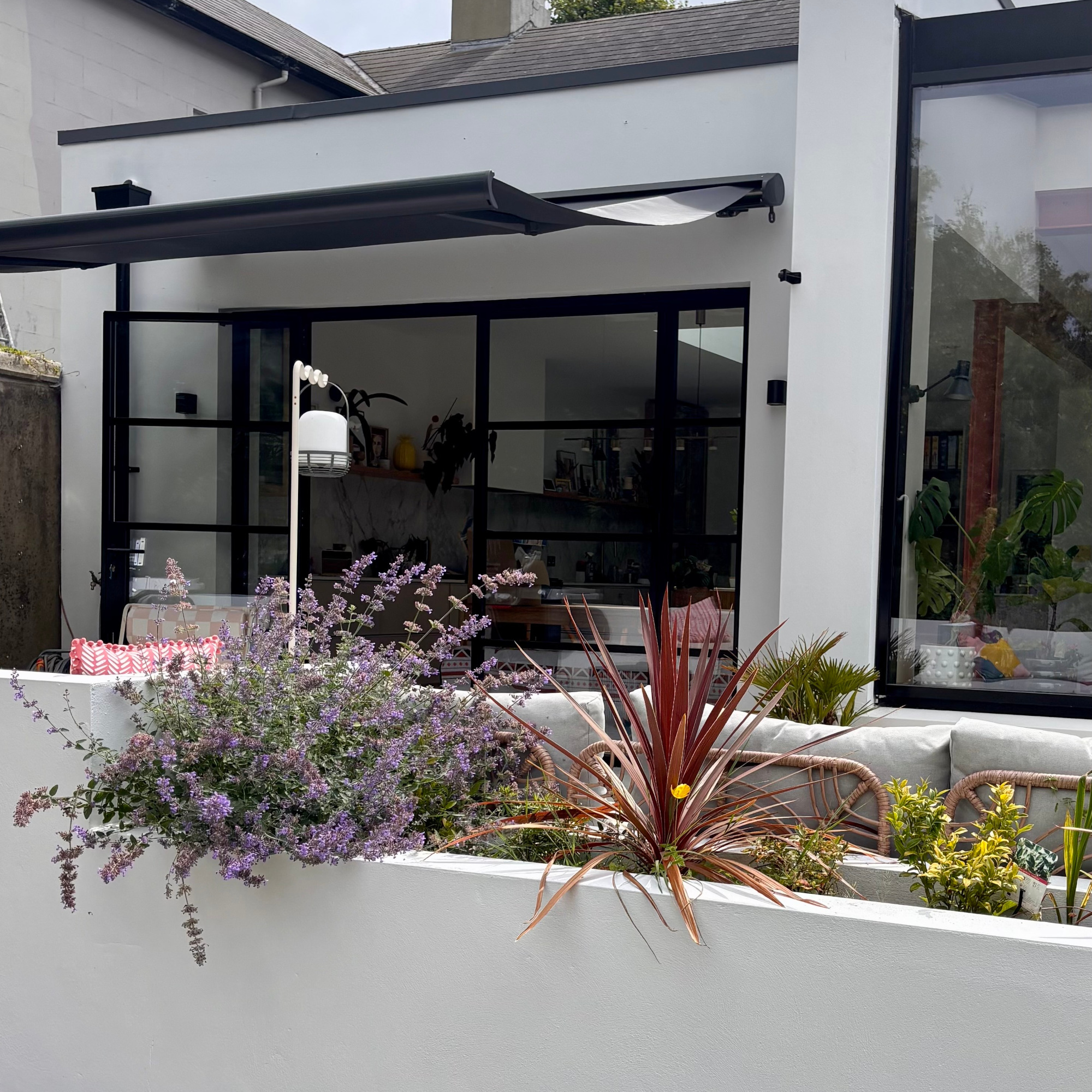 patio and rear extension of house with open crank awning