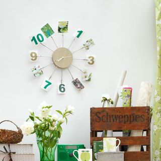 clock on wall with mug and flower vase