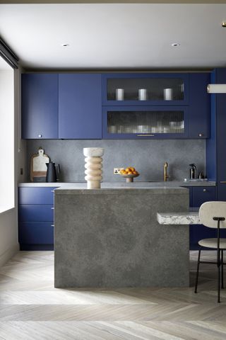 A kitchen with blue cabinets and wooden flooring