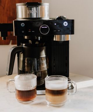 Ninja Espresso & Coffee Barista System with two ribbed glass cups with handles showing prepared coffee in foreground