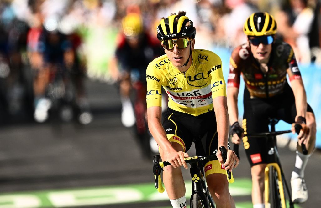 UAE Team Emirates teams Slovenian rider Tadej Pogacar wearing the overall leaders yellow jersey L cycles past the finish line during the 9th stage of the 109th edition of the Tour de France cycling race 1929 km between Aigle in Switzerland and Chatel Les Portes du Soleil in the French Alps on July 10 2022 Photo by Marco BERTORELLO AFP Photo by MARCO BERTORELLOAFP via Getty Images