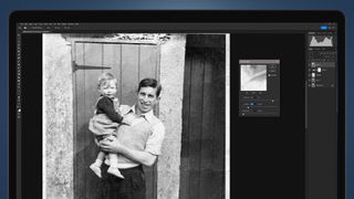 A laptop screen showing an old photo being restored in Photoshop