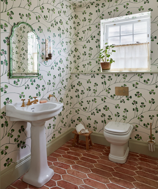 bathroom with clover wallpaper and red stone floors