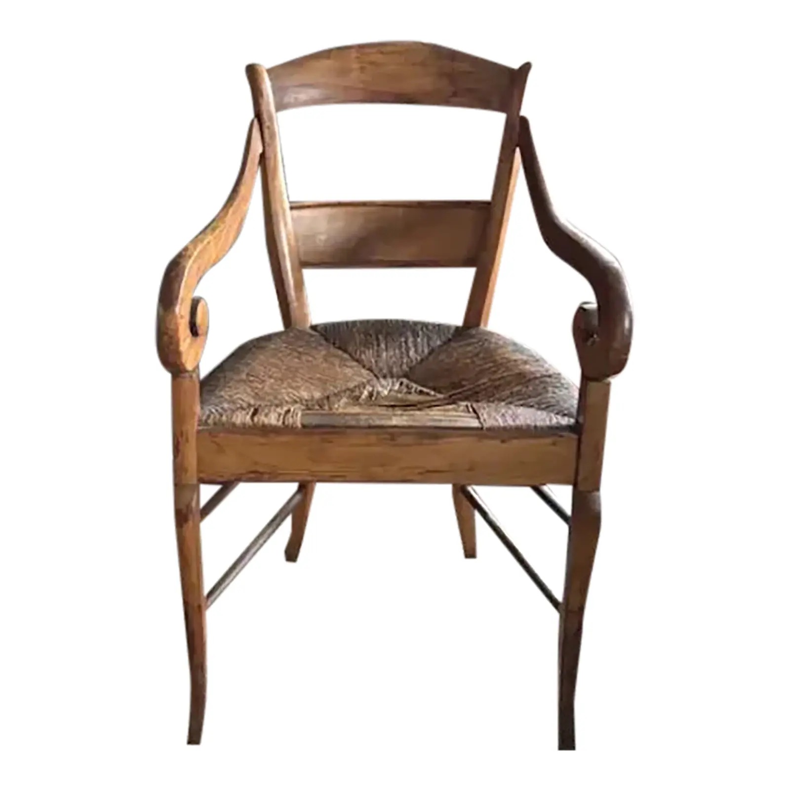 Antique French scroll armchair with curved wooden arms, a woven rush seat, and slender saber legs, offering compact seating with classic character.