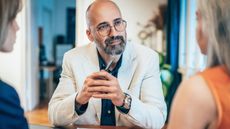 A financial professional listens thoughtfully to his clients as they talk.