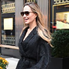 Angelina Jolie smiles wearing aviator sunglasses