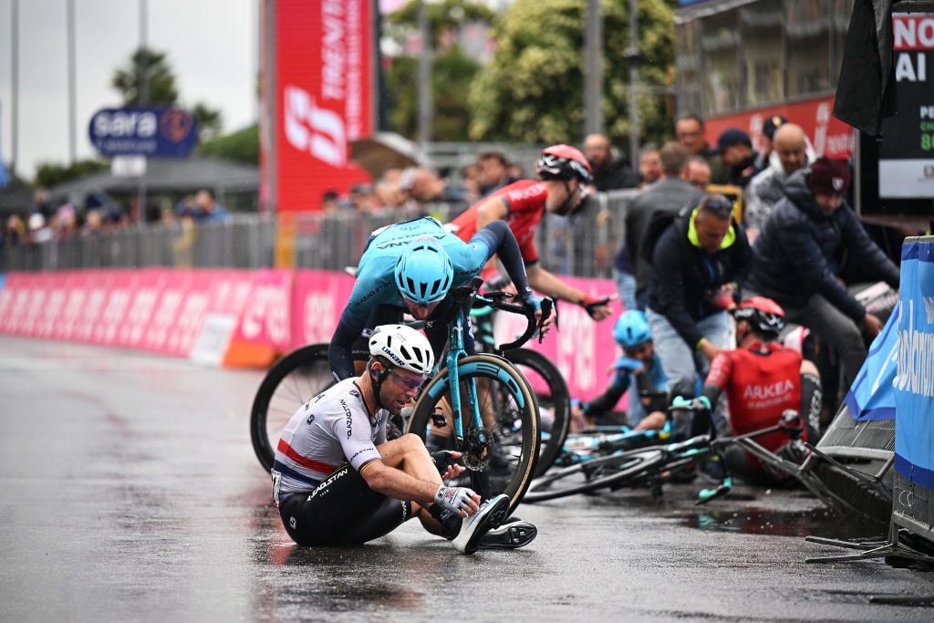 Mark Cavendish sits on the ground as several other riders recover from the finish-line crash on stage 5 of the Giro d&#039;Italia