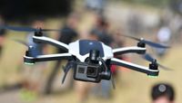 The GoPro Karma drone with an action camera attached flies through the air
