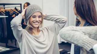 A woman trying on a beanie hat in a shop