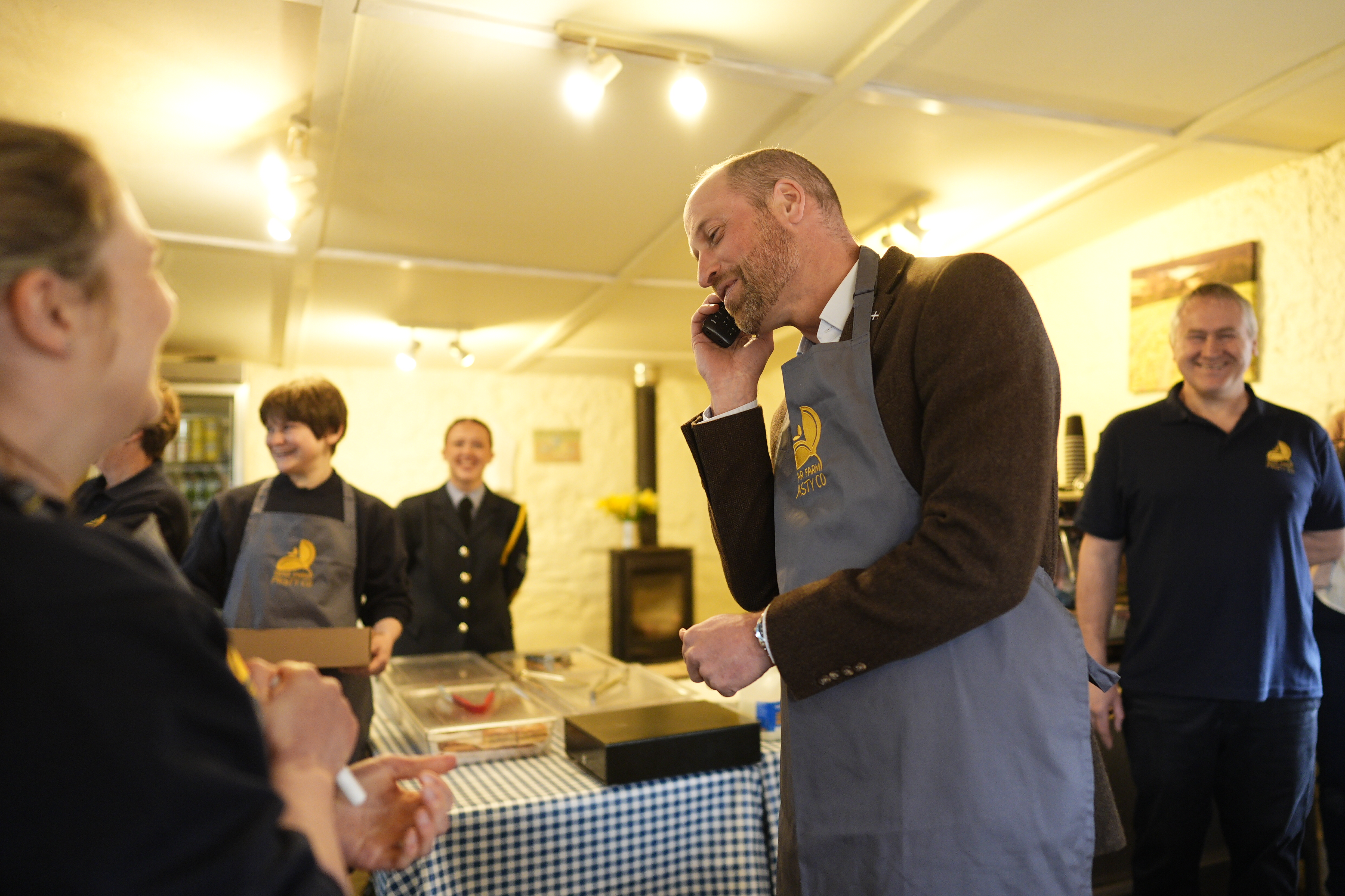 Prince William answering a phone at a bakery