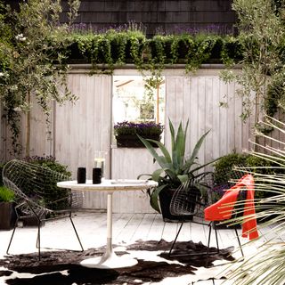 garden with wooden wall and table with chairs