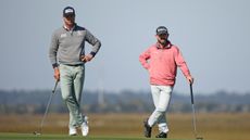 Harris English (left) and Brian Harman lean on their putters with one hand and put the other hand on their hips during the 2023 RSM Classic
