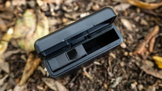 Kandao QooCam 3 Ultra action camera battery charger outside on a brown leafy ground