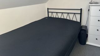 Eight Sleep Pod 4 on metal bed frame with main Hub next to bed