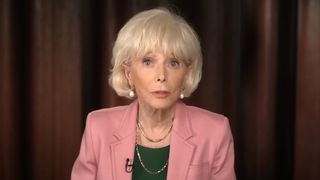 Lesley Stahl speaking to camera in pink jacket and green shirt during segment about Spinal Tap on 60 Minutes