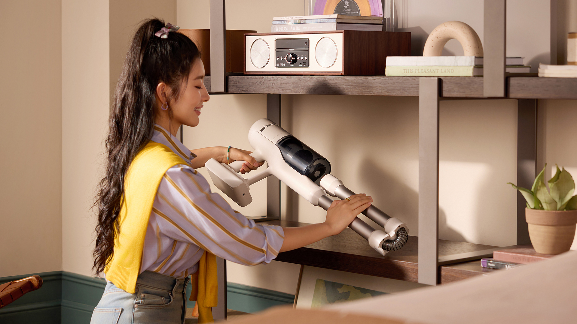 Roborock H60 vacuum being folded up and placed on a shelf