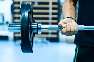 An image of a man's arm lifting a weight.