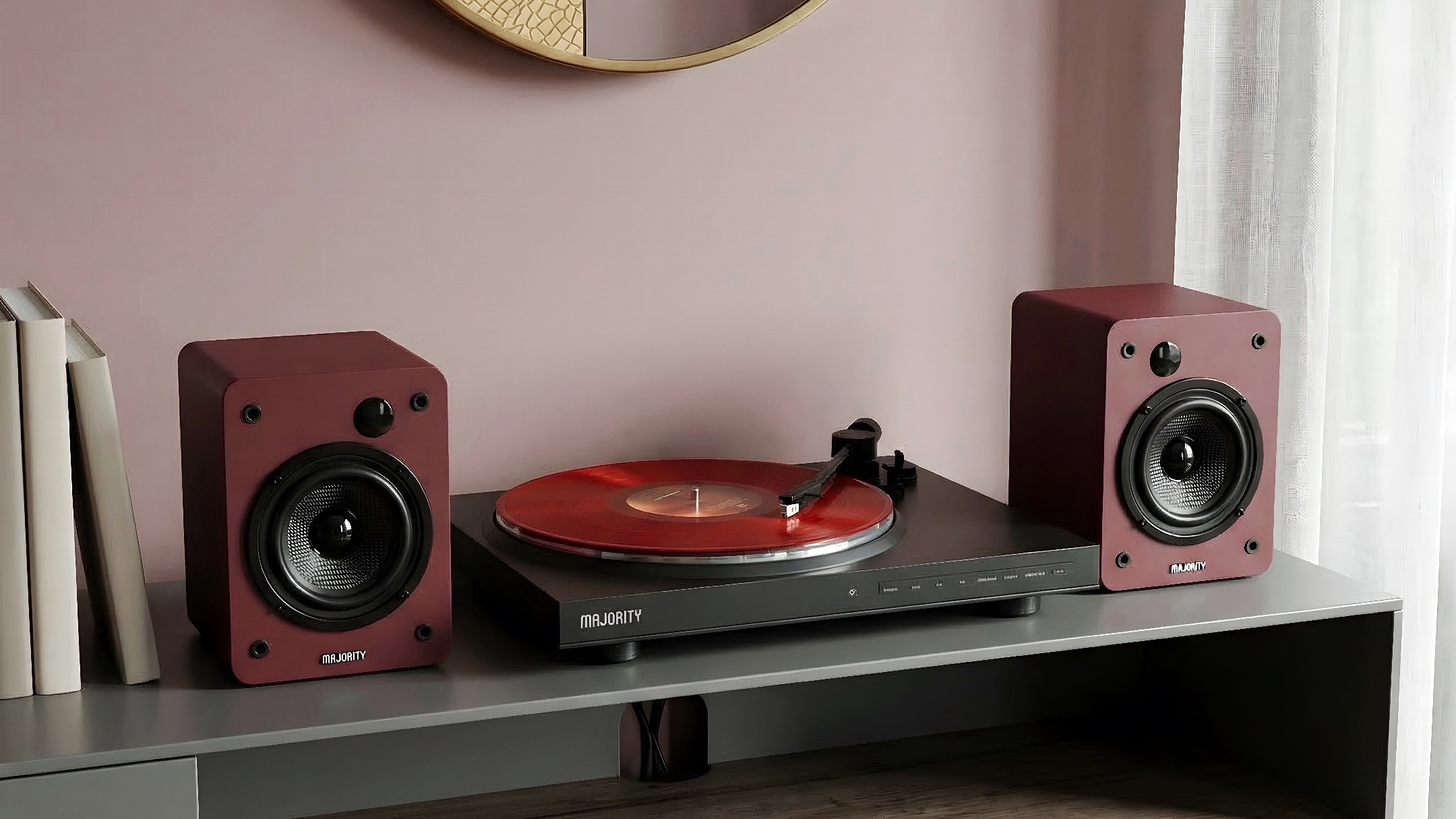A black Majority Auto record player flanked by a pair of red Majority D50X speakers on a side unit.