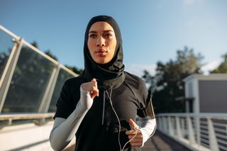 Healthy sporty woman wearing hijab jogging outdoors in the city. Islamic woman running early in the morning. How to run for longer