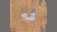 An orange-colored parchment is fragmented and covered in Greek letters