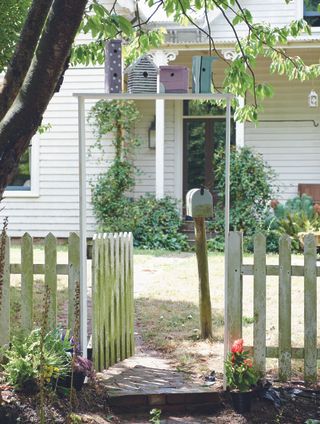 Birdhouses in a row over a gateway to a cottage from Pallet wood projects for outdoor spaces by CICO Books