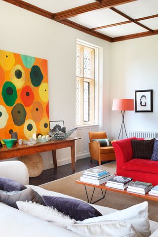 living room with art and red sofa
