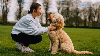 Woman crouched down facing her dog