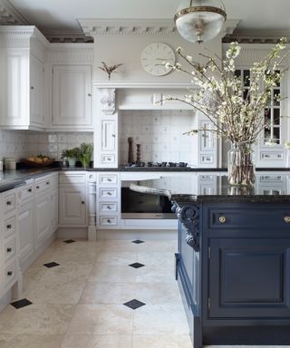 kitchen with white cabinets and dark gray island and glass globe pendant