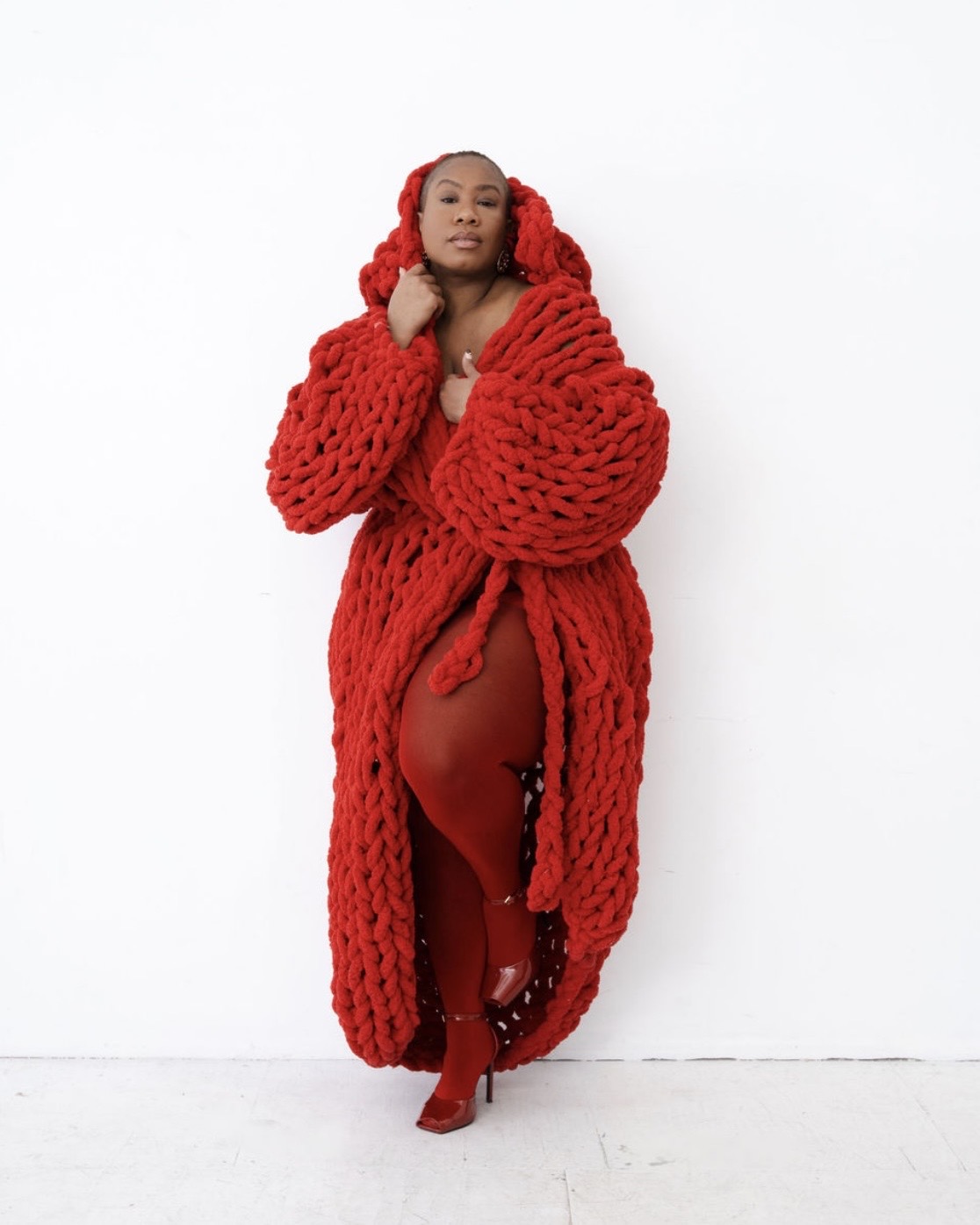 Kelly Augustine in a red sweater coat and tights