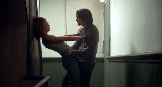 diane lane leans against a wall and pushes olivier martinez in a hallway in the movie Unfaithful