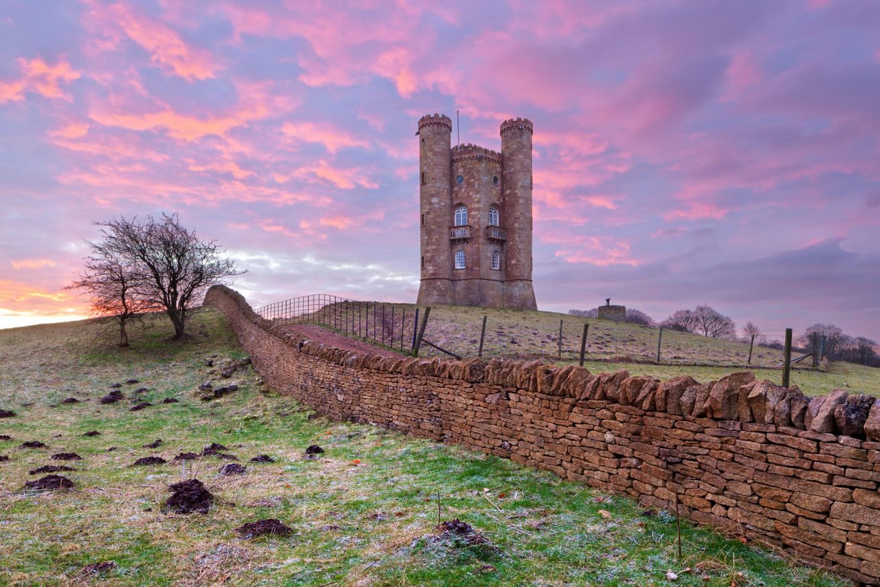 Broadway Tower with its Cotswold dry-stone wall at sunrise.