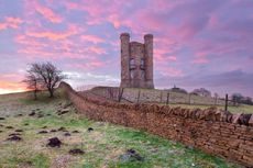 Broadway Tower with its Cotswold dry-stone wall at sunrise.