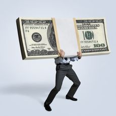 Businessman holding big bundle of money