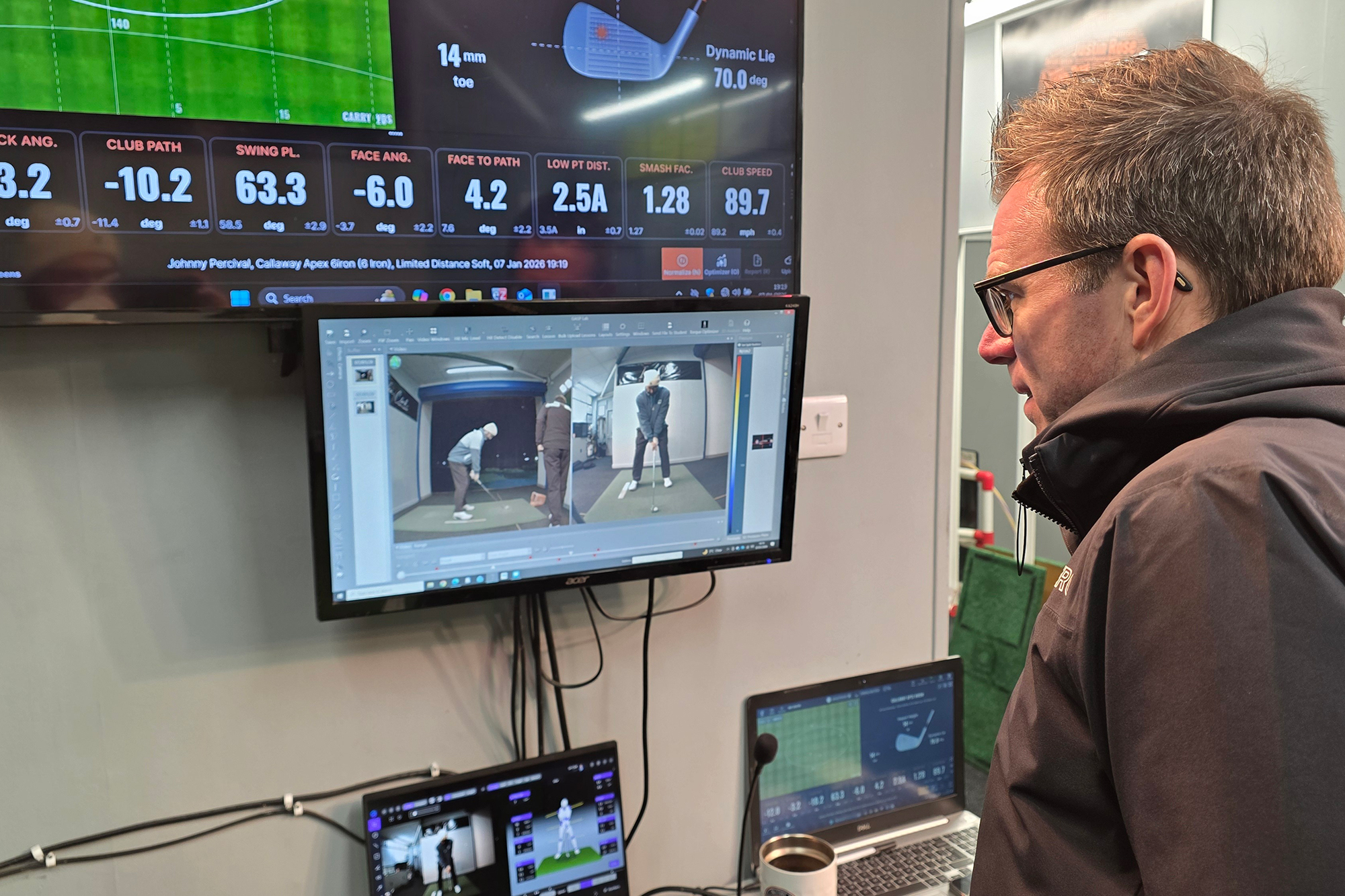 Ian Clark reviewing and analysing data from Johnny Percival's swing during a golf lesson