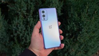 A OnePlus 9 from the back, held in someone's hand