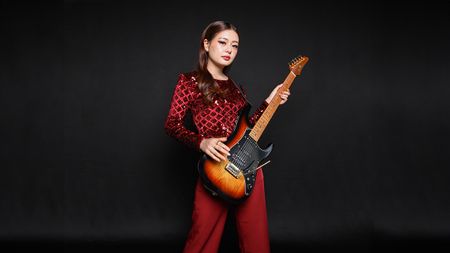 Imnainla Jamir with an Ibanez guitar