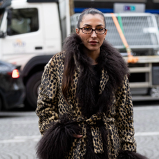 PARIS, FRANCE - MARCH 10: A guest wears brown glasses, a leopard printed coat with brown fur applications, a black sweater and black leather knee high boots outside Rokh during the Womenswear Fall/Winter 2025/2026 as part of Paris Fashion Week on March 10, 2025 in Paris, France. (Photo by Valentina Frugiuele/Getty Images)